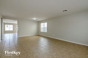 Marana house for rent - A spacious empty room with tiled flooring and white walls.
