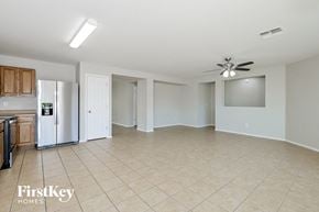 Marana house for rent - A spacious room with a kitchen area and a ceiling fan.