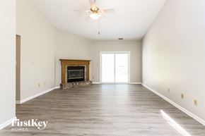 Indianapolis house for rent - A spacious room with a fireplace and a ceiling fan.