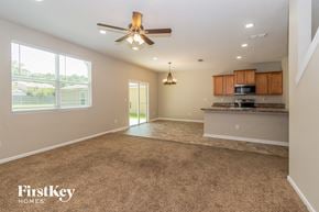 Jacksonville house for rent - an empty kitchen and living room with a ceiling fan