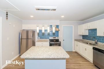 Collierville house for rent - a kitchen with white cabinets and granite counter tops and stainless steel appliances