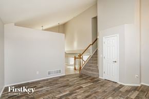 Fountain house for rent - the living room and entryway of a house with white walls and wood floors