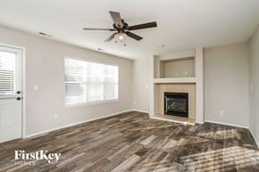 Fountain house for rent - a living room with a fireplace and a ceiling fan