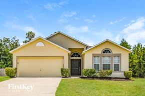 Middleburg house for rent - a yellow house with a garage door and a lawn