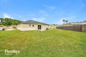 Middleburg house for rent - a backyard with a yellow house and a grass field