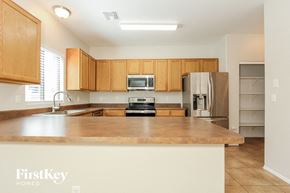 Tucson house for rent - a kitchen with wooden cabinets and a large counter top