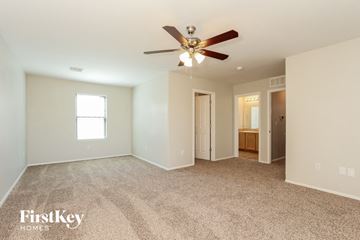 Tucson house for rent - a spacious living room with carpet and a ceiling fan