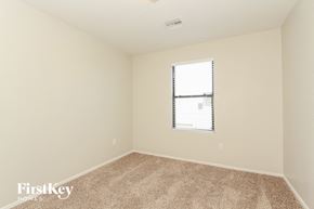 Tucson house for rent - a spacious room with carpet and a window