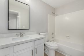 Avondale house for rent - A white bathroom with a toilet, sink, and bathtub.