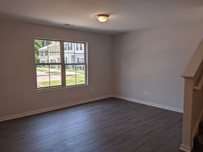 Raleigh house for rent - A room with a large window and wooden flooring.