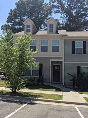 Raleigh house for rent - A two-story house with a grey facade and a black door.