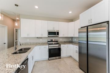 Cape Coral house for rent - A kitchen with white cabinets and stainless steel appliances.