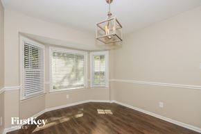 Gastonia house for rent - a living room with a large window and a chandelier