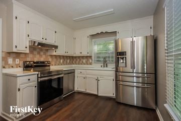 Gastonia house for rent - a kitchen with stainless steel appliances and white cabinets