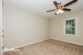 Gastonia house for rent - a bedroom with a ceiling fan and a window