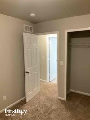 Colorado Springs house for rent - a bedroom with a closet and a white door and a hallway with a door open