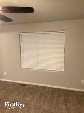 Colorado Springs house for rent - a living room with a window and a ceiling fan