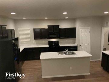 Colorado Springs house for rent - a kitchen with a sink and black cabinets