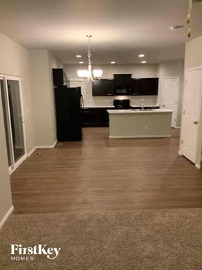 Colorado Springs house for rent - an empty kitchen and living room with hard wood flooring