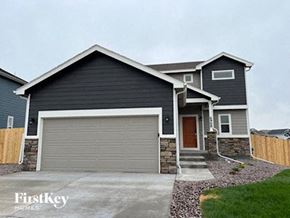 Colorado Springs house for rent - a gray garage door in front of a house