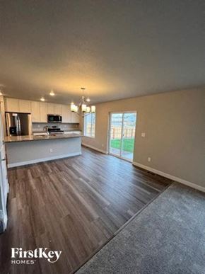 Colorado Springs house for rent - an empty living room and kitchen with wood floors