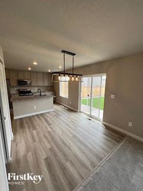 Colorado Springs house for rent - a kitchen and a living room with wood flooring