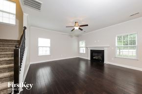 Clemmons house for rent - an empty living room with a ceiling fan and a fireplace
