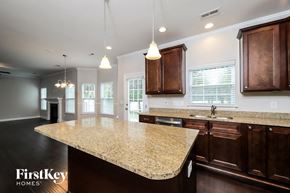 Clemmons house for rent - a kitchen with a marble counter top and wooden cabinets