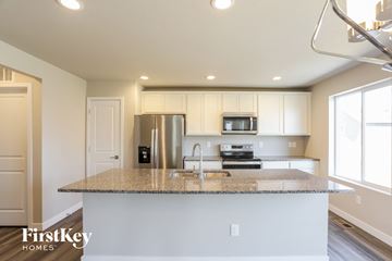 Colorado Springs house for rent - a kitchen with a granite counter top and a stainless steel refrigerator