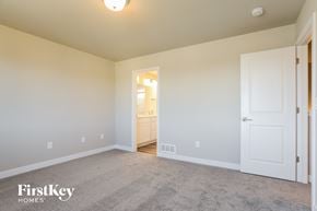 Colorado Springs house for rent - a bedroom with a carpeted floor and a door to a bathroom
