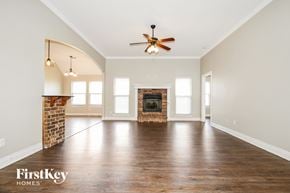 Yukon house for rent - A spacious room with a fireplace and a ceiling fan.