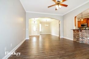 Yukon house for rent - A spacious room with wooden floors and a ceiling fan.