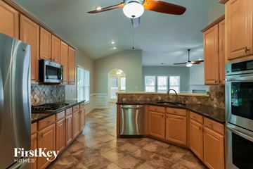 Villa Rica house for rent - a kitchen with wooden cabinets and stainless steel appliances