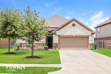 Pearland house for rent - a house with a tree in the yard and a garage door