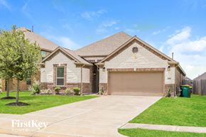 Pearland house for rent - a white brick house with a garage door