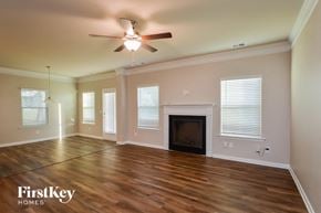 Covington house for rent - an empty living room with a ceiling fan and a fireplace