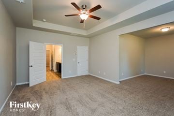 Covington house for rent - a living room with carpet and a ceiling fan