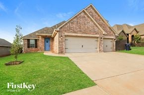 Edmond house for rent - a large brick house with a blue door and a lawn