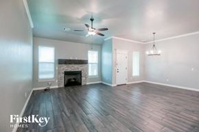 Edmond house for rent - a living room with a fireplace and a ceiling fan
