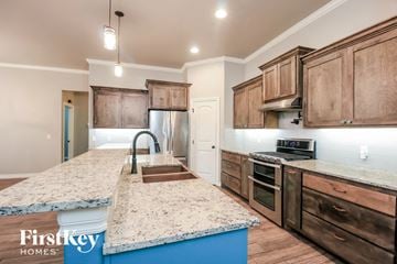 Edmond house for rent - a kitchen with wooden cabinets and granite counter tops and a sink
