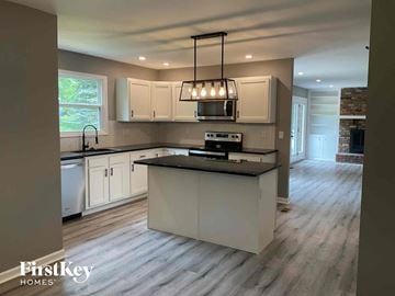 Fairfield house for rent - a kitchen with white cabinets and a black counter top