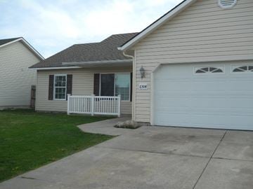 Rathdrum house for rent - a white house with a driveway and a white garage door