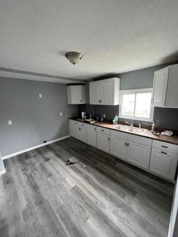 Akron apartment for rent - A kitchen with white cabinets and a grey floor.