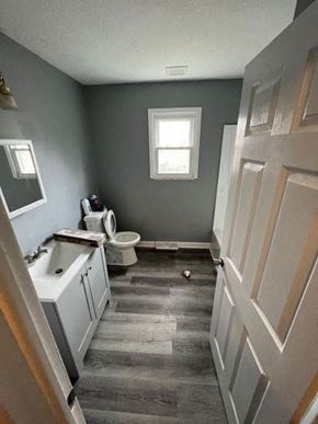 Akron apartment for rent - A bathroom with a toilet, sink, and window.