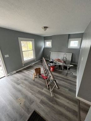 Akron apartment for rent - A room with grey walls and a grey floor with a ladder and a table.