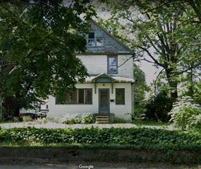 Akron house for rent - A white house with a grey roof and a green door.