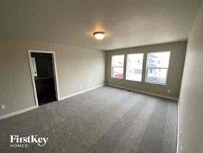 Colorado Springs house for rent - an empty living room with a door to a window