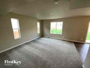 Colorado Springs house for rent - an empty living room with windows and a rug