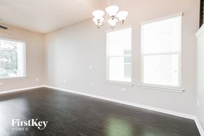 Oakland house for rent - a bedroom with wood floors and three windows
