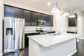 Oakland house for rent - a kitchen with black cabinets and a white counter top
